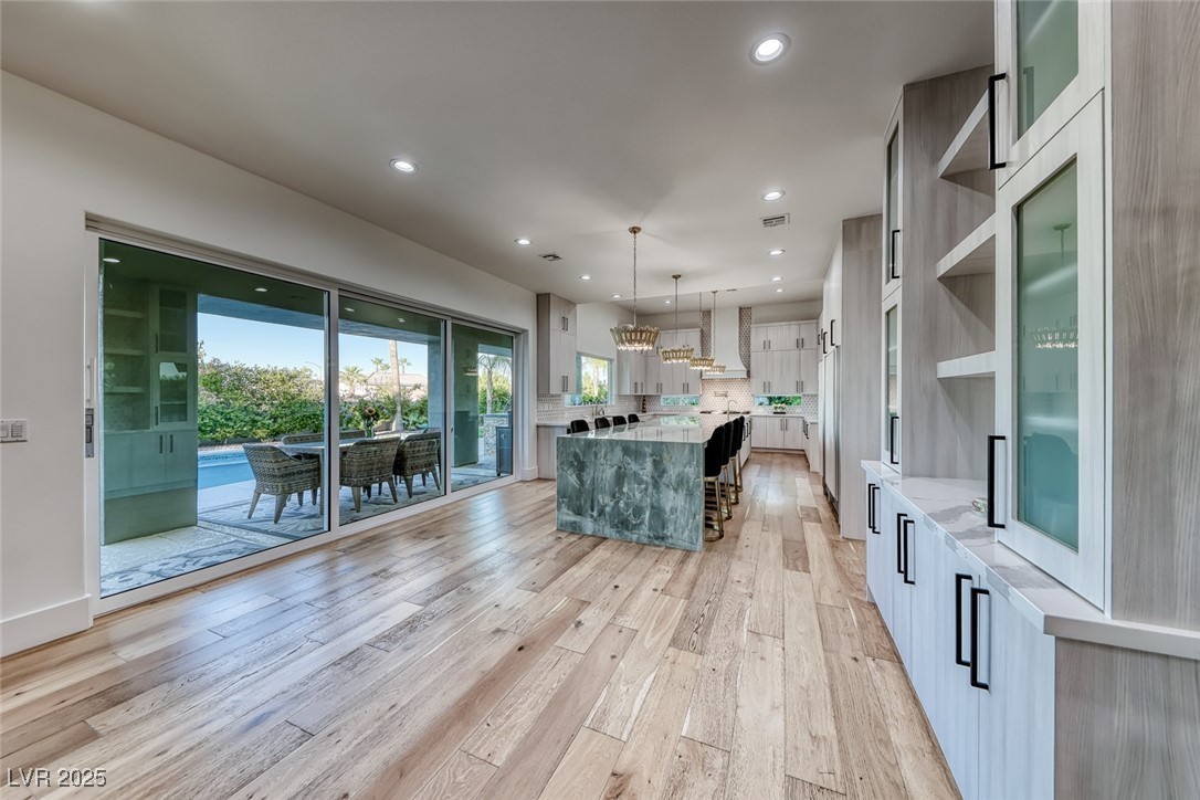 2309 Prometheus Court Henderson, NV 89074 - Photo 17 of 70 Kitchen with open shelves, pendant lighting, light wood finished floors, light stone counters, and recessed lighting