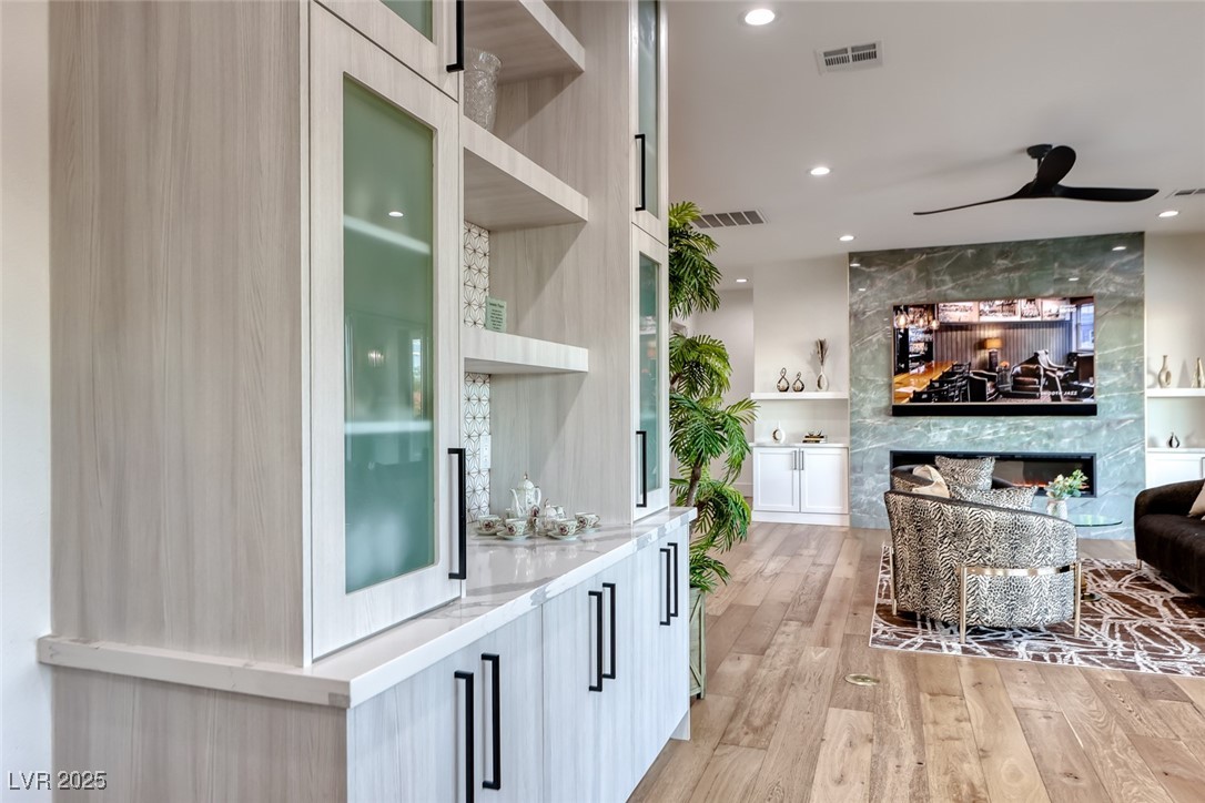 2309 Prometheus Court Henderson, NV 89074 - Photo 23 of 70 Bar with modern cabinets, open shelves, built in features, light wood finished floors, and ceiling fan