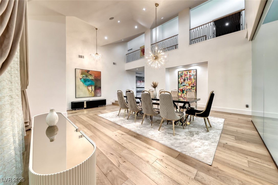 2309 Prometheus Court Henderson, NV 89074 - Photo 28 of 70 Dining room featuring light wood-style flooring, a towering ceiling, recessed lighting, and a chandelier