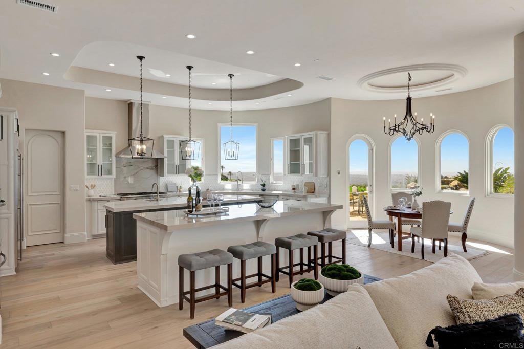 8025 La Milla Rancho Santa Fe, CA 92067 - Photo 13 of 51 a large kitchen with cabinets chairs and a dining table