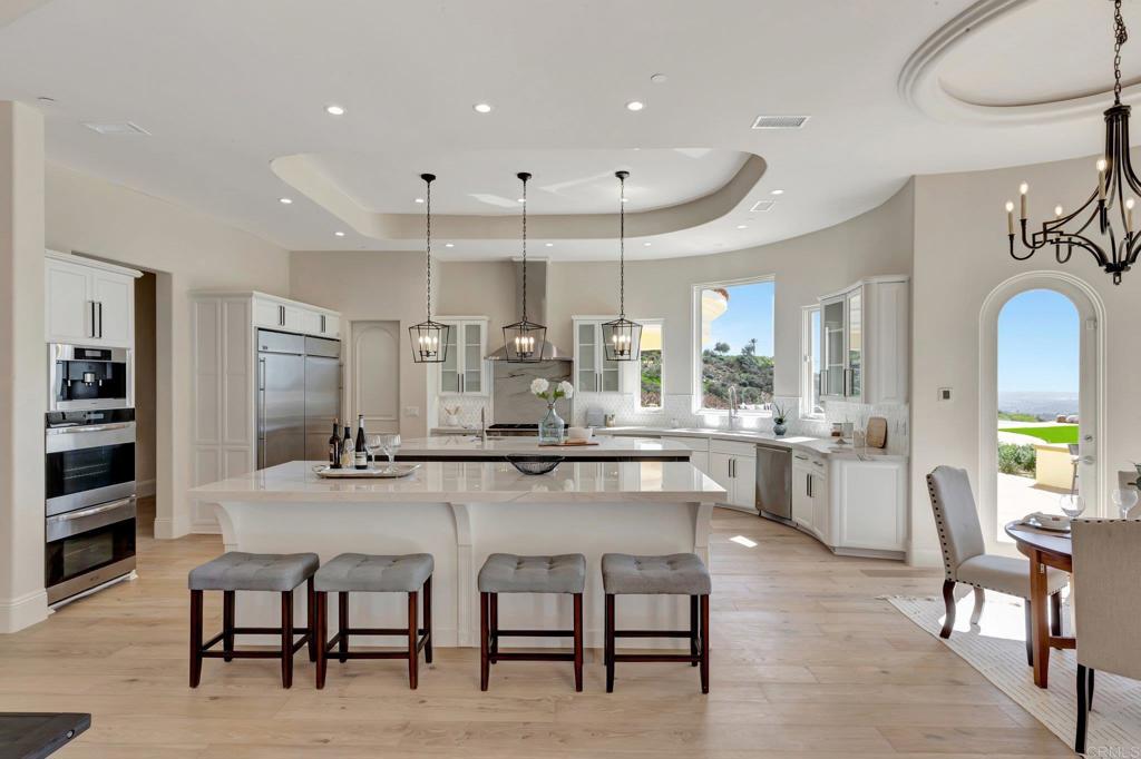 8025 La Milla Rancho Santa Fe, CA 92067 - Photo 18 of 51 a large kitchen with a table and chairs