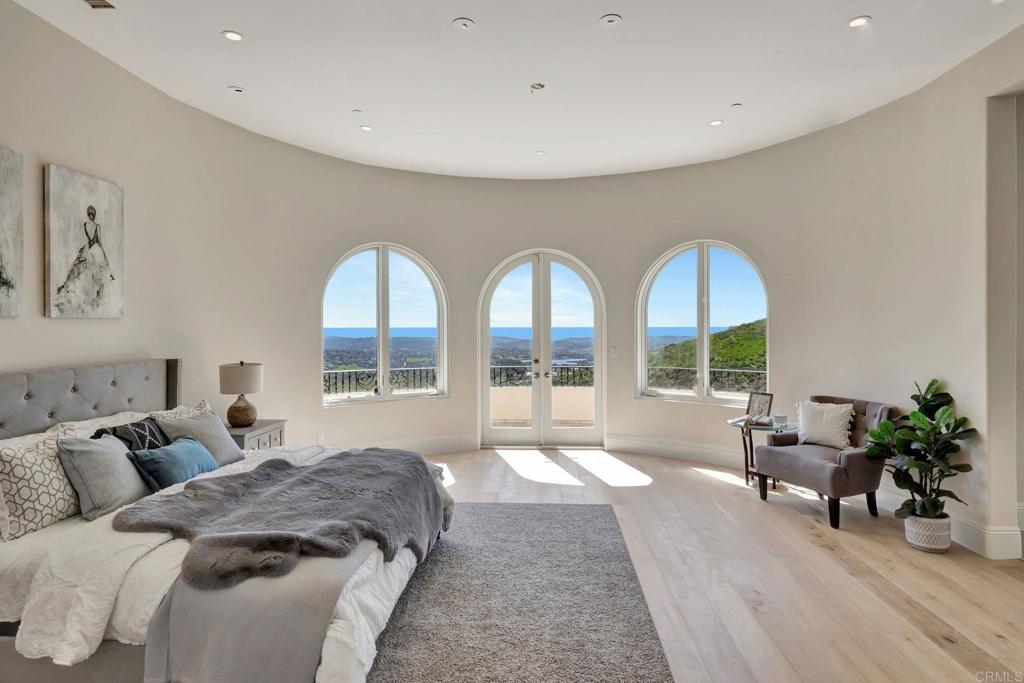 8025 La Milla Rancho Santa Fe, CA 92067 - Photo 21 of 51 a spacious bedroom with a bed and glass windows