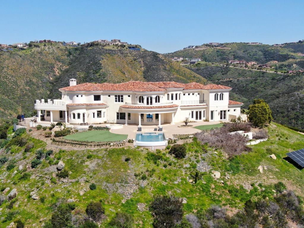 8025 La Milla Rancho Santa Fe, CA 92067 - Photo 3 of 51 a view of a white house with a big yard and large trees