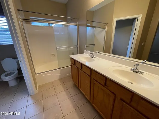 a bathroom with a double vanity sink toilet and shower