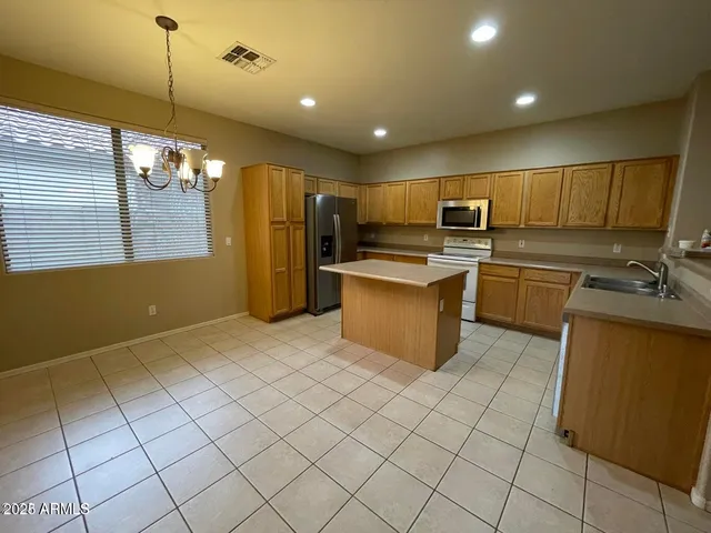 a kitchen with kitchen island a counter top space appliances and cabinets