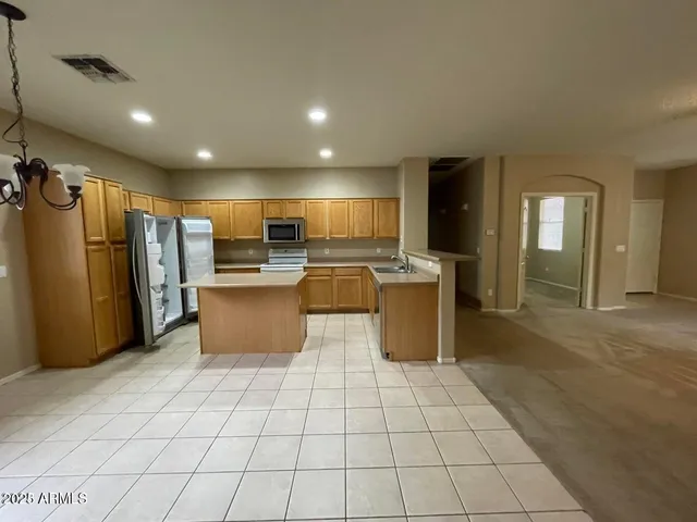 a kitchen with stainless steel appliances granite countertop a refrigerator and a sink