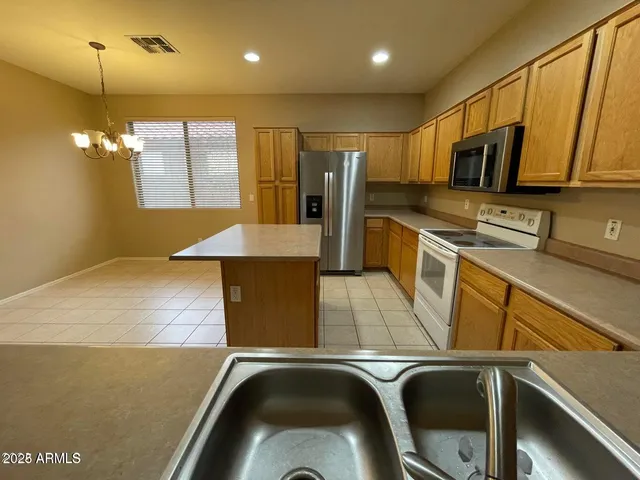 a kitchen with stainless steel appliances granite countertop a sink a stove counter space and cabinets