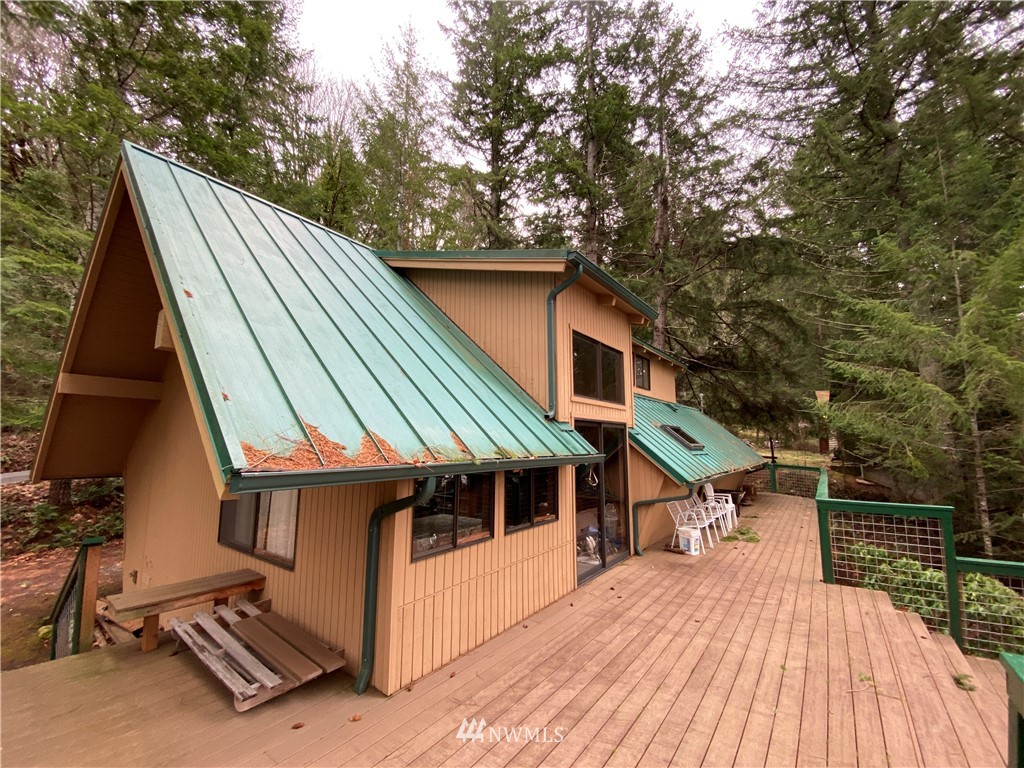 2300 East Quilcene Road Quilcene, WA 98376 - Photo 3 of 9 a house with trees in front of it