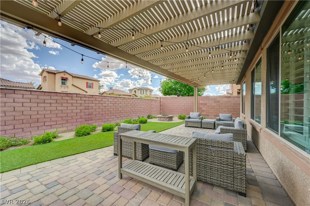 7049 Motley Road Las Vegas, NV 89178 - Photo 47 of 61 An inviting paver patio rests beneath a structured pergola in a private yard.
