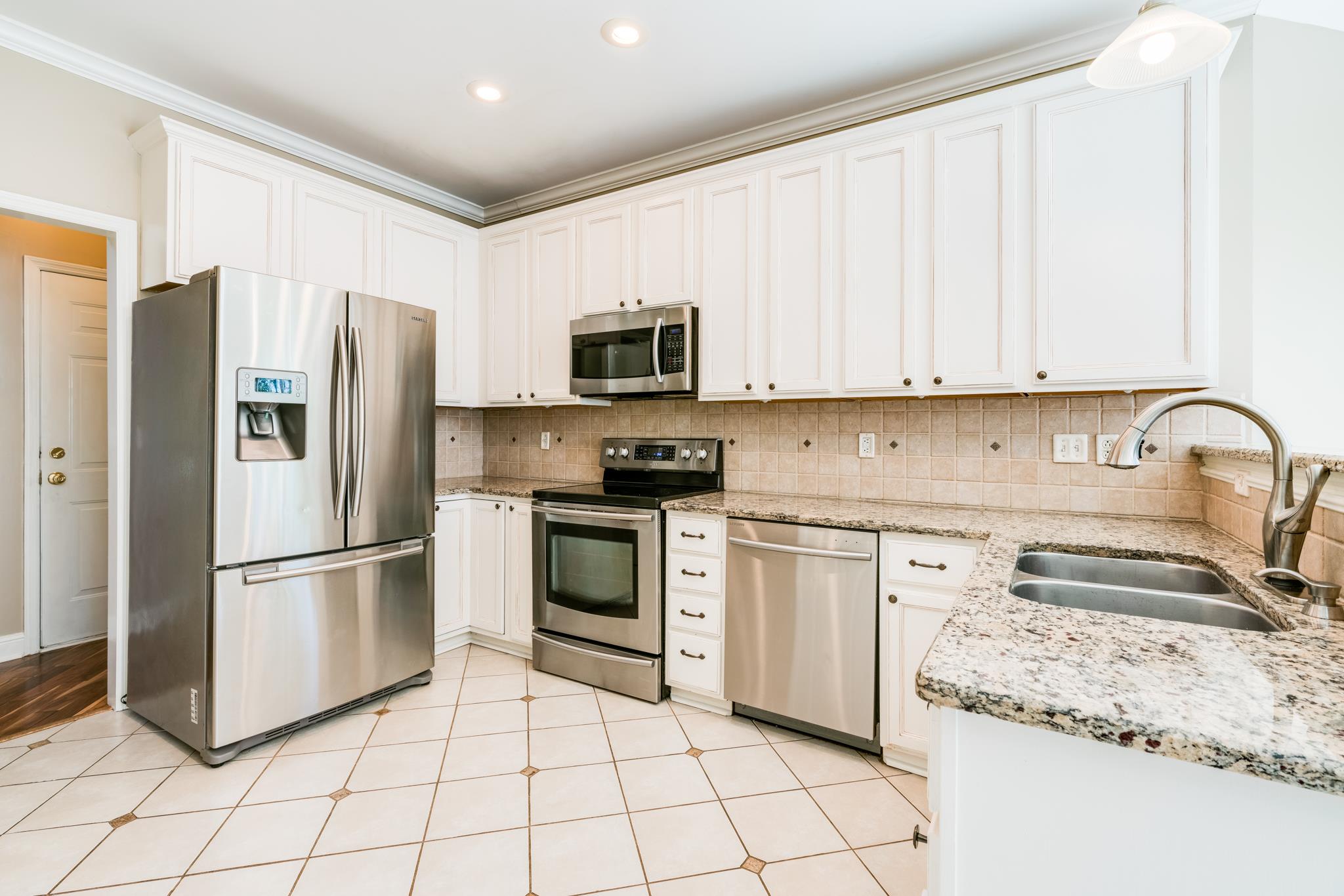 3126 Vera Valley Road Franklin, TN 37064 - Photo 12 of 30 a kitchen with granite countertop a refrigerator and a stove top oven