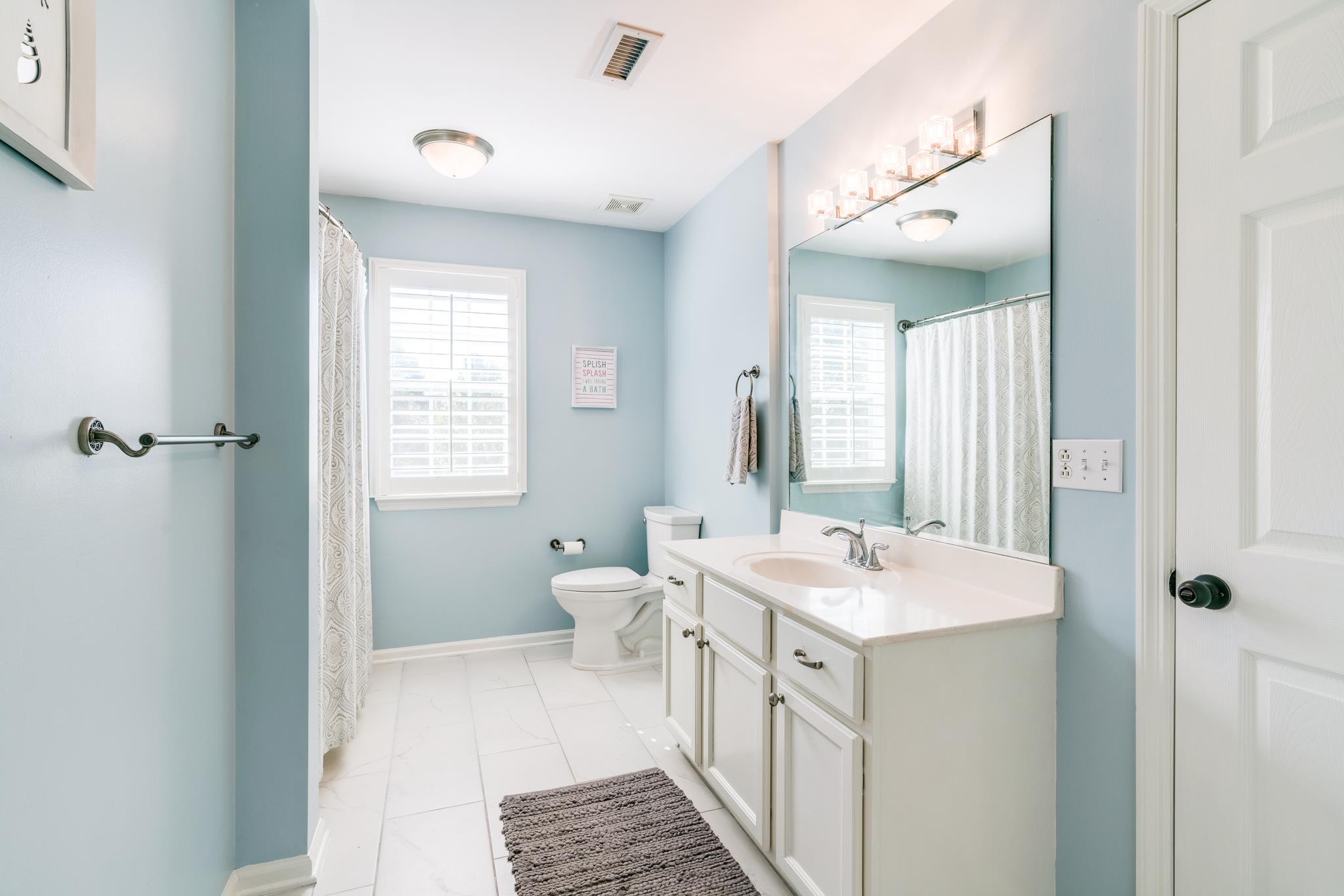 3126 Vera Valley Road Franklin, TN 37064 - Photo 22 of 30 a bathroom with a sink a toilet a mirror and a window