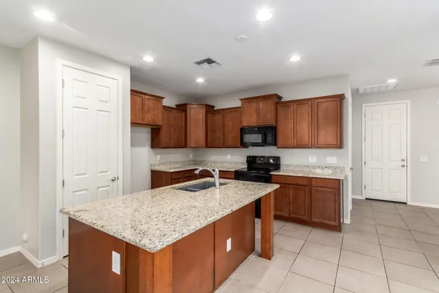 a kitchen with stainless steel appliances granite countertop a sink stove and cabinets
