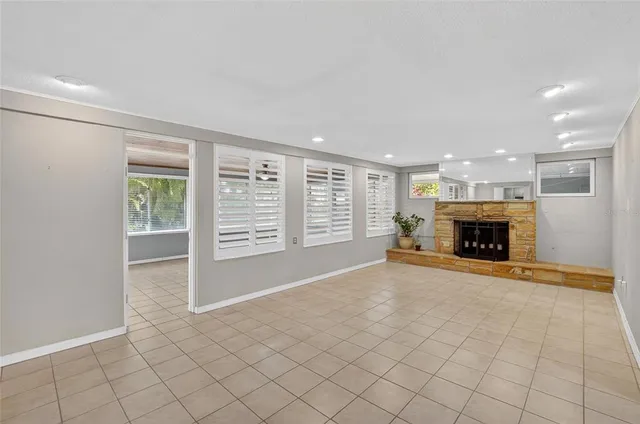 a view of an empty room with a fireplace and a window
