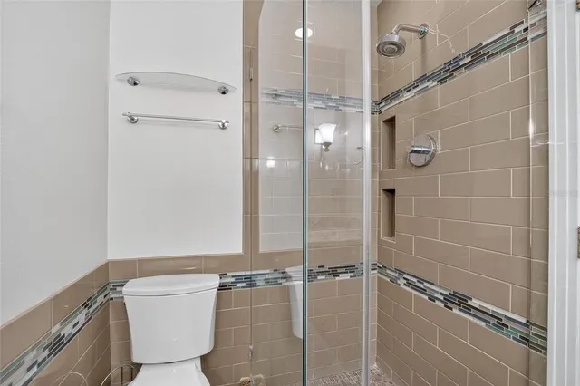 an empty room with windows bathroom and front door