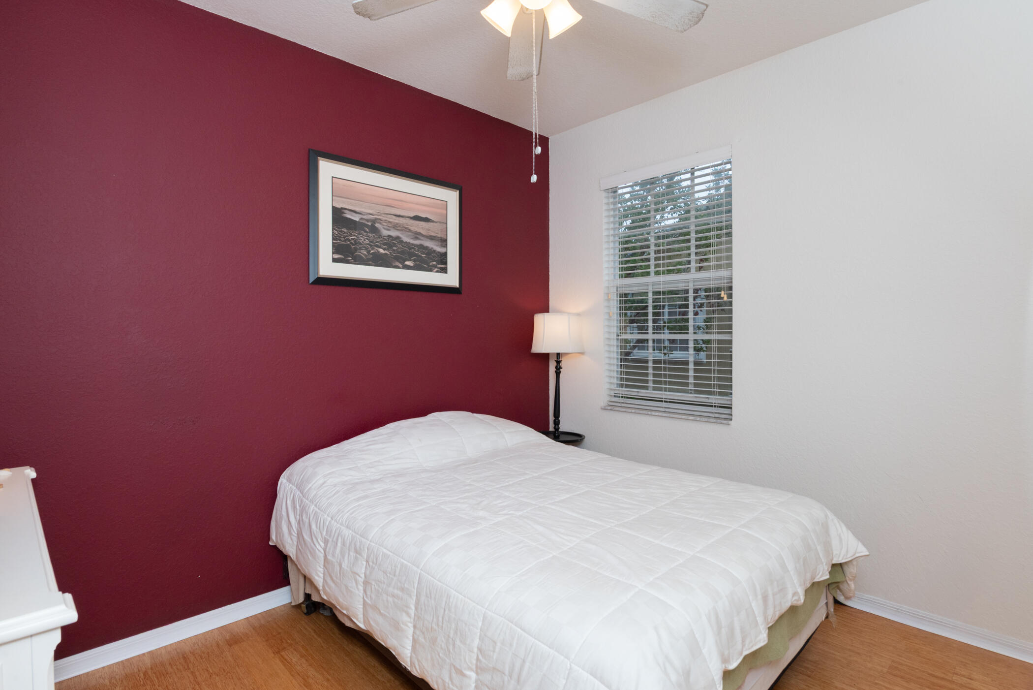 1600 Southeast Sheffield Terrace, Unit 201 Stuart, FL 34994 - Photo 20 of 28 a bed sitting in a bedroom next to a window