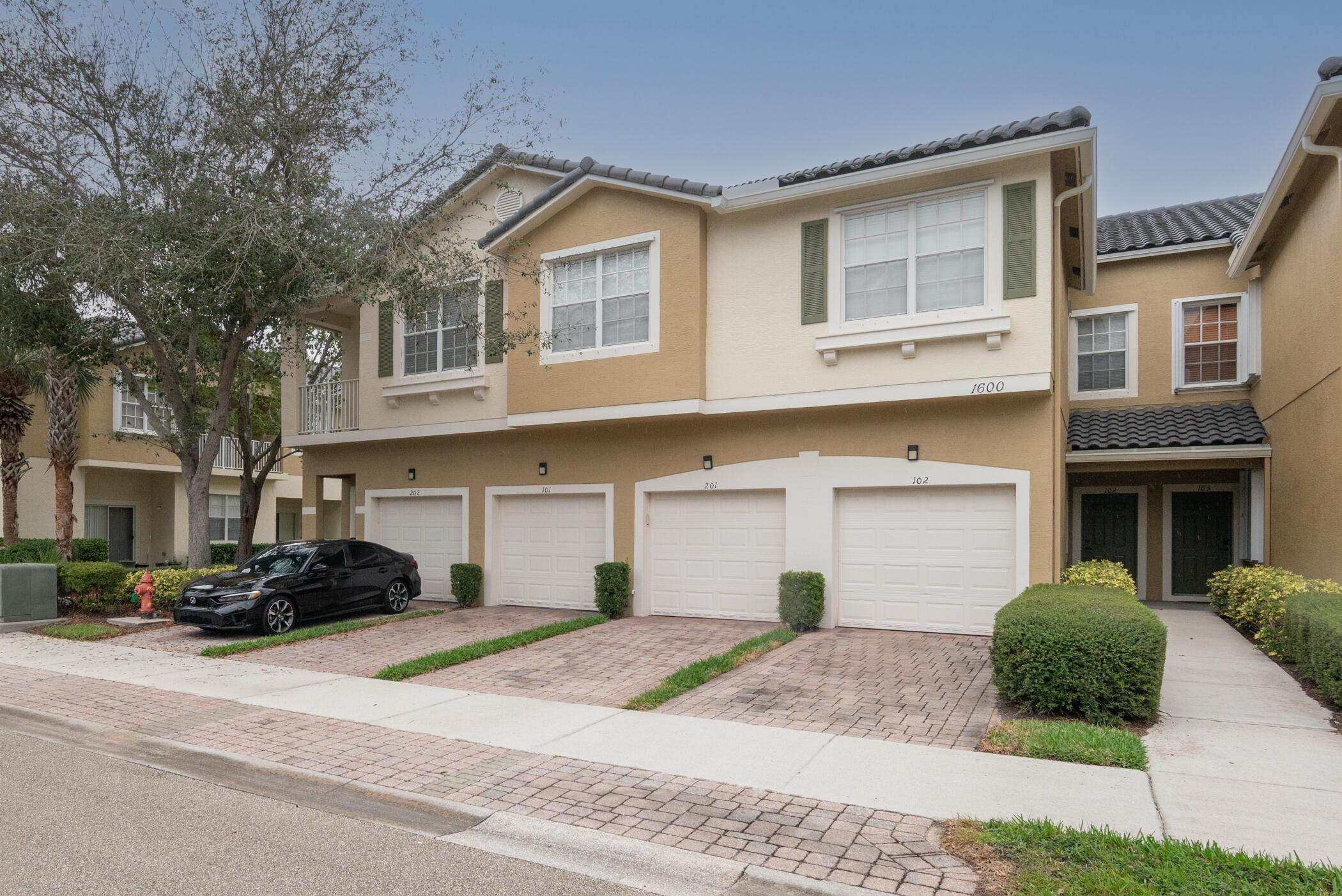 1600 Southeast Sheffield Terrace, Unit 201 Stuart, FL 34994 - Photo 2 of 28 a front view of a house with a yard and garage