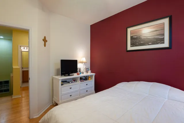 a bedroom with a bed and a flat screen tv