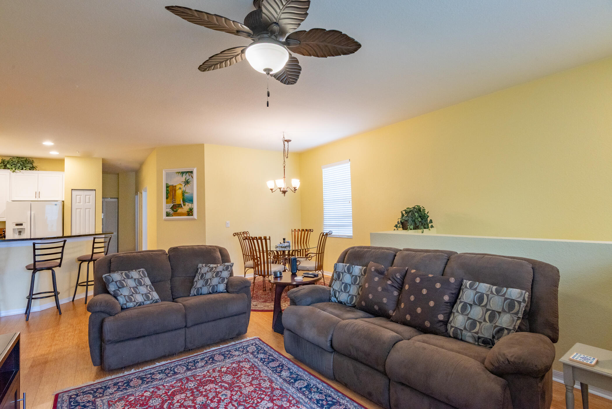 1600 Southeast Sheffield Terrace, Unit 201 Stuart, FL 34994 - Photo 9 of 28 a living room with furniture ceiling fan and a rug