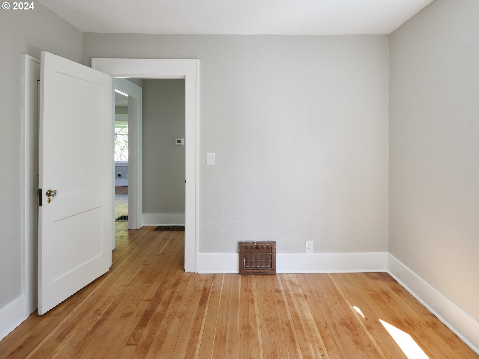 10342 Southeast Ramona Street Portland, OR 97266 - Photo 12 of 17 a view of a hallway with wooden floor and a bathroom