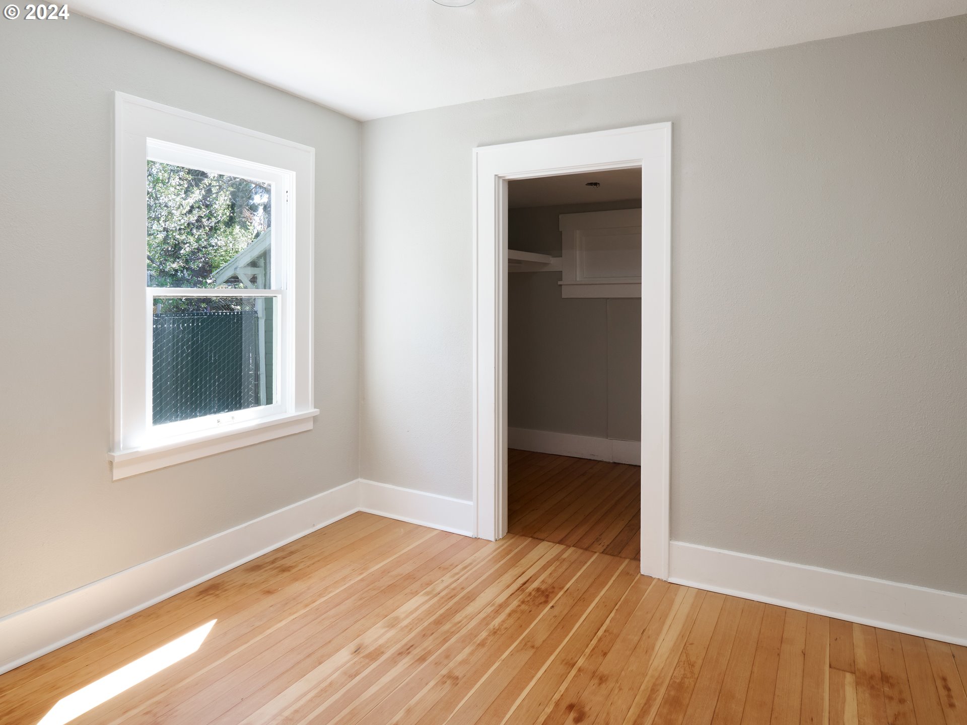 10342 Southeast Ramona Street Portland, OR 97266 - Photo 13 of 17 a view of an empty room with wooden floor and a window