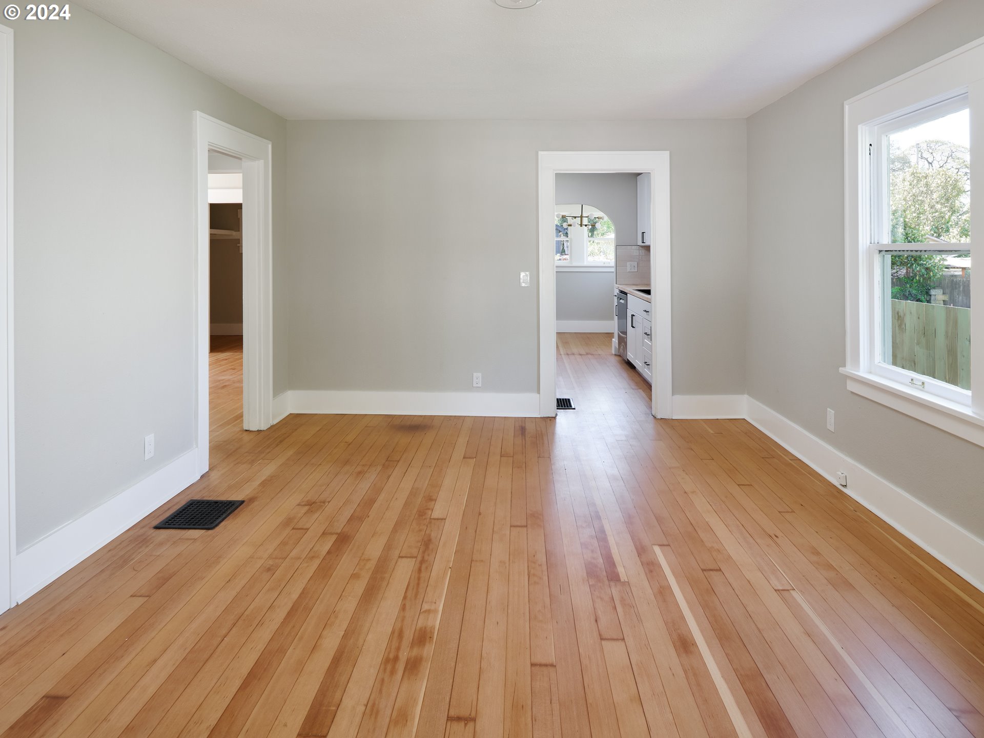10342 Southeast Ramona Street Portland, OR 97266 - Photo 5 of 17 an empty room with wooden floor and windows