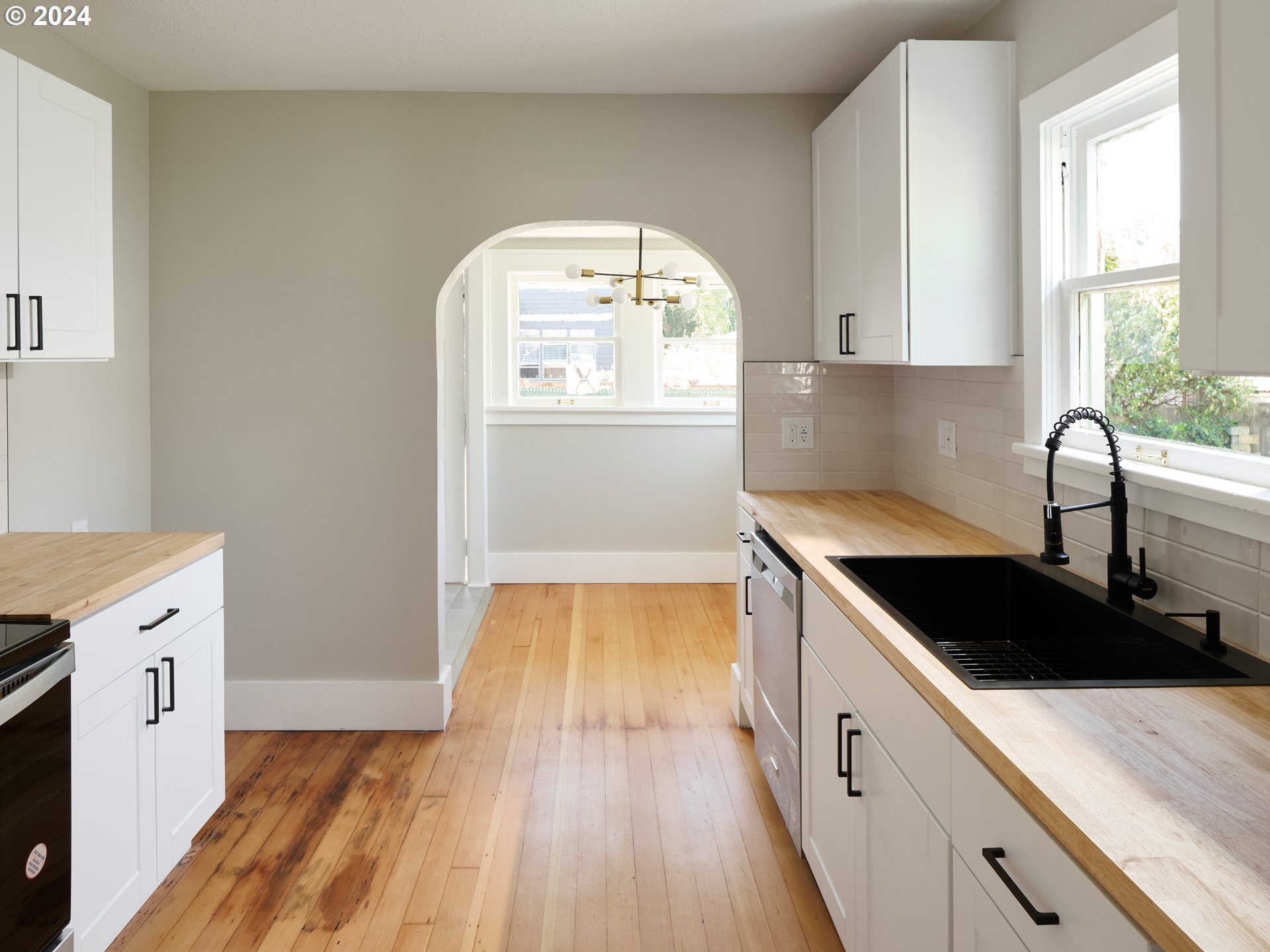 10342 Southeast Ramona Street Portland, OR 97266 - Photo 7 of 17 a kitchen with a sink a stove and cabinets
