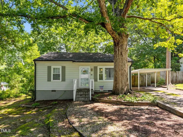 a backyard of a house with yard table and chairs
