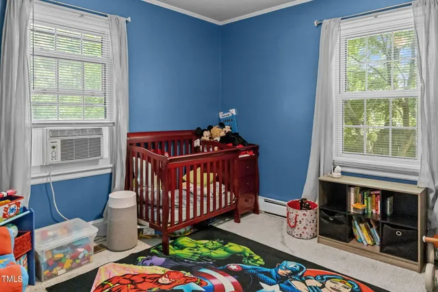 a bedroom with baby crib and a window