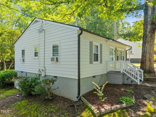 a view of a small house with yard and plants