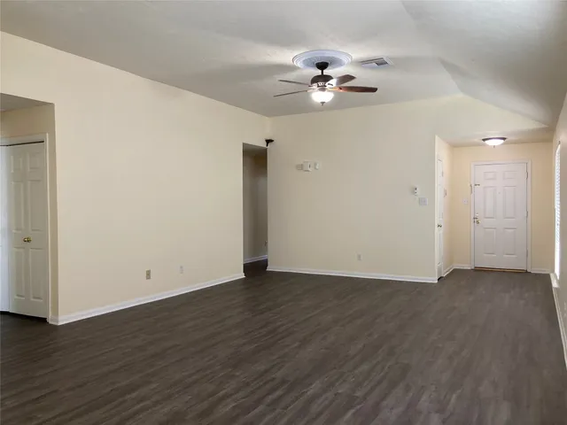 a view of an empty room with wooden floor