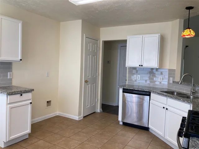 a kitchen with granite countertop white cabinets and white appliances