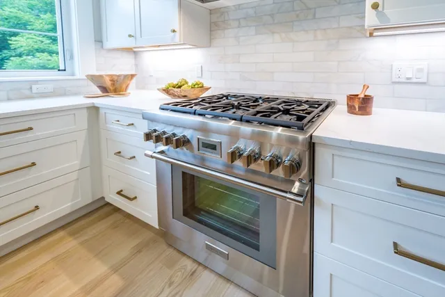 a kitchen with white cabinets and appliances
