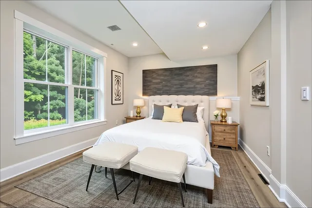a bedroom with a bed and a large window