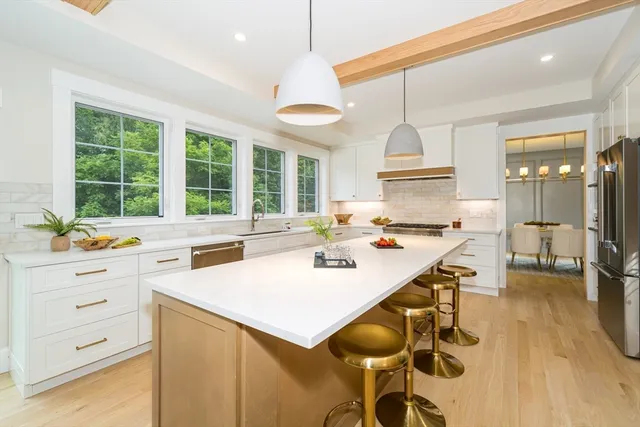 a kitchen with a stove a sink a dining table and chairs