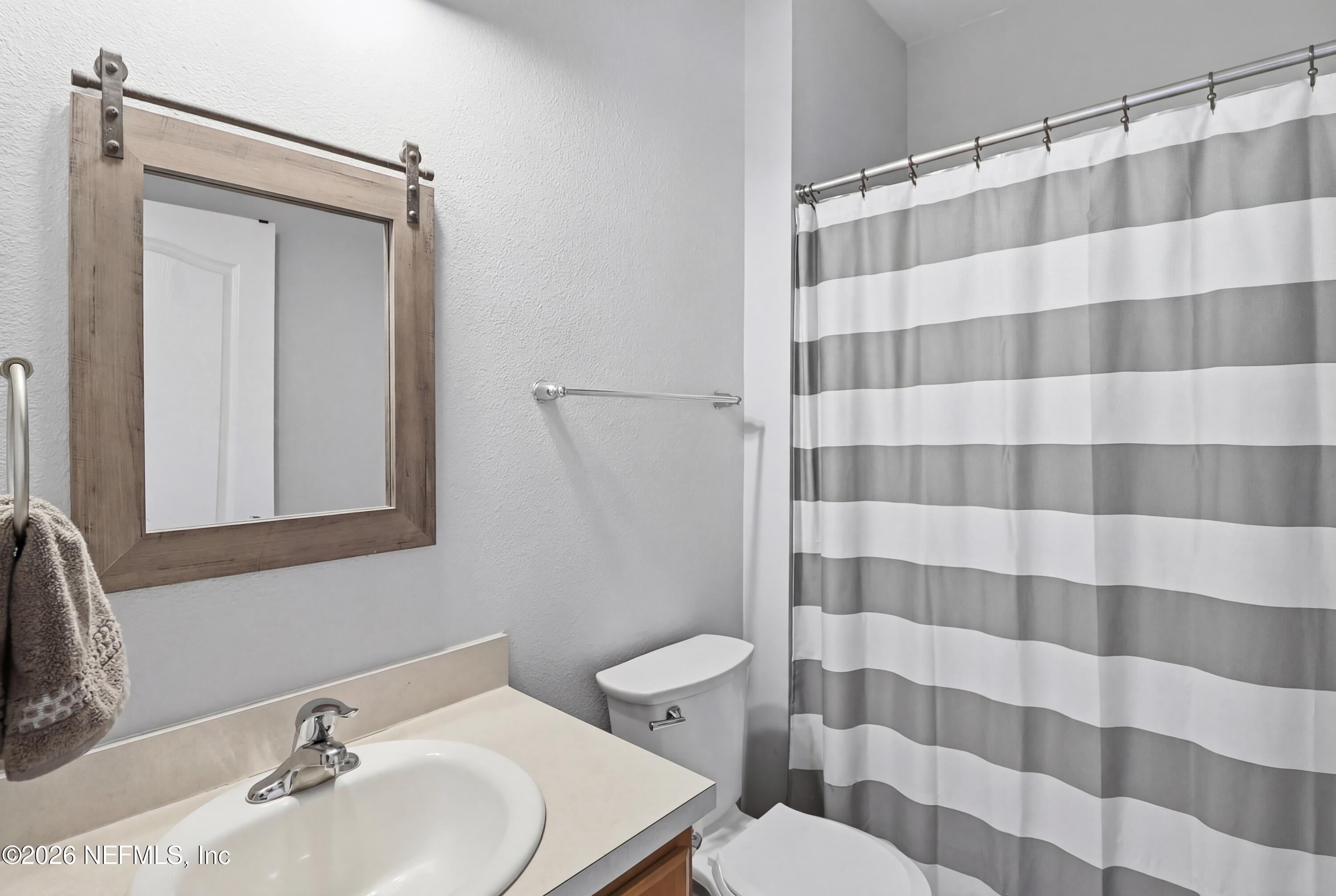 3825 Bronco Road Middleburg, FL 32068 - Photo 16 of 18 a bathroom with a sink and mirror with toilet
