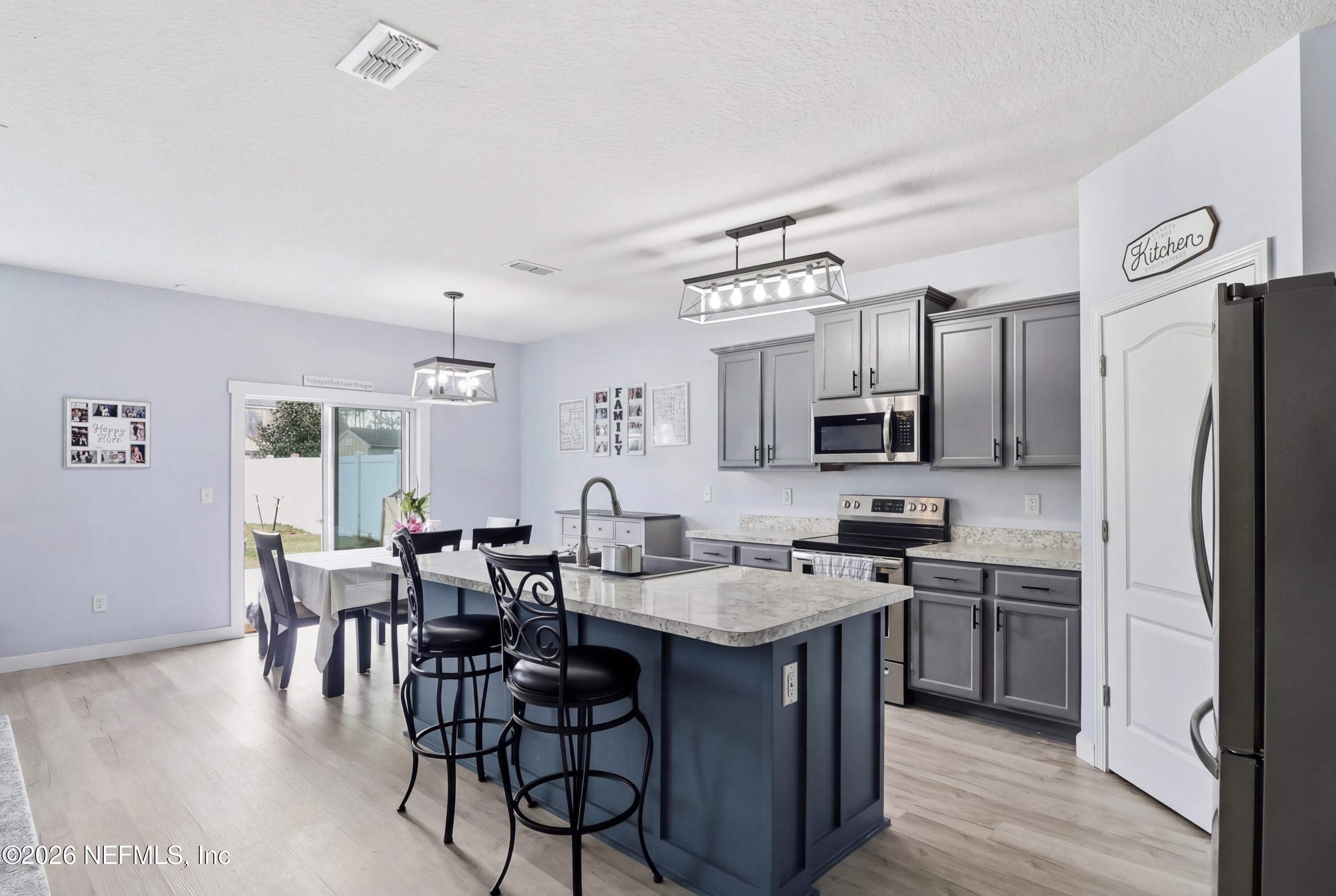3825 Bronco Road Middleburg, FL 32068 - Photo 2 of 18 a kitchen with stainless steel appliances granite countertop a sink a stove a refrigerator and chairs