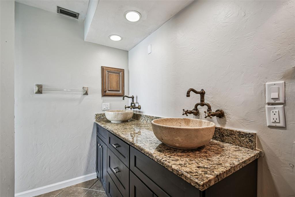 529 Johns Pass Avenue Madeira Beach, FL 33708 - Photo 31 of 100 a bathroom with a granite countertop sink and a mirror