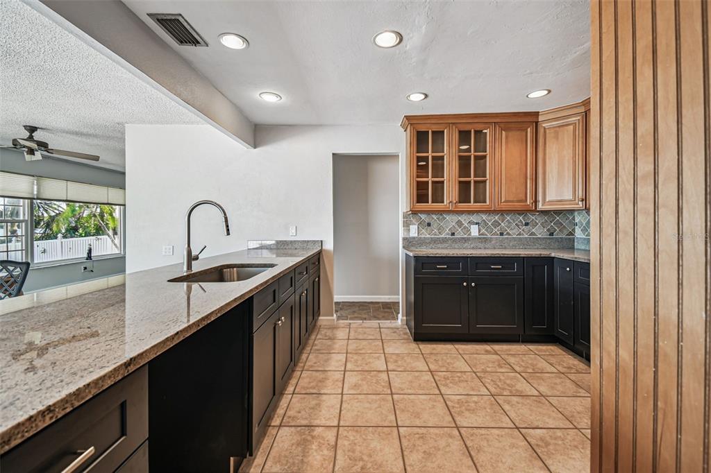 529 Johns Pass Avenue Madeira Beach, FL 33708 - Photo 41 of 100 a kitchen with stainless steel appliances granite countertop a stove a sink and a refrigerator