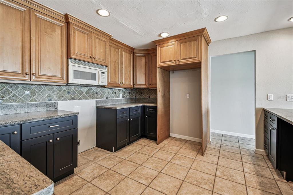 529 Johns Pass Avenue Madeira Beach, FL 33708 - Photo 43 of 100 a kitchen with stainless steel appliances granite countertop a refrigerator and a stove top oven