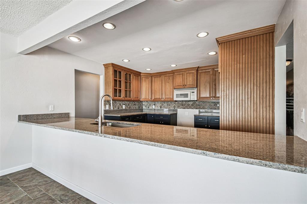 529 Johns Pass Avenue Madeira Beach, FL 33708 - Photo 47 of 100 a large kitchen with kitchen island a sink stainless steel appliances and cabinets