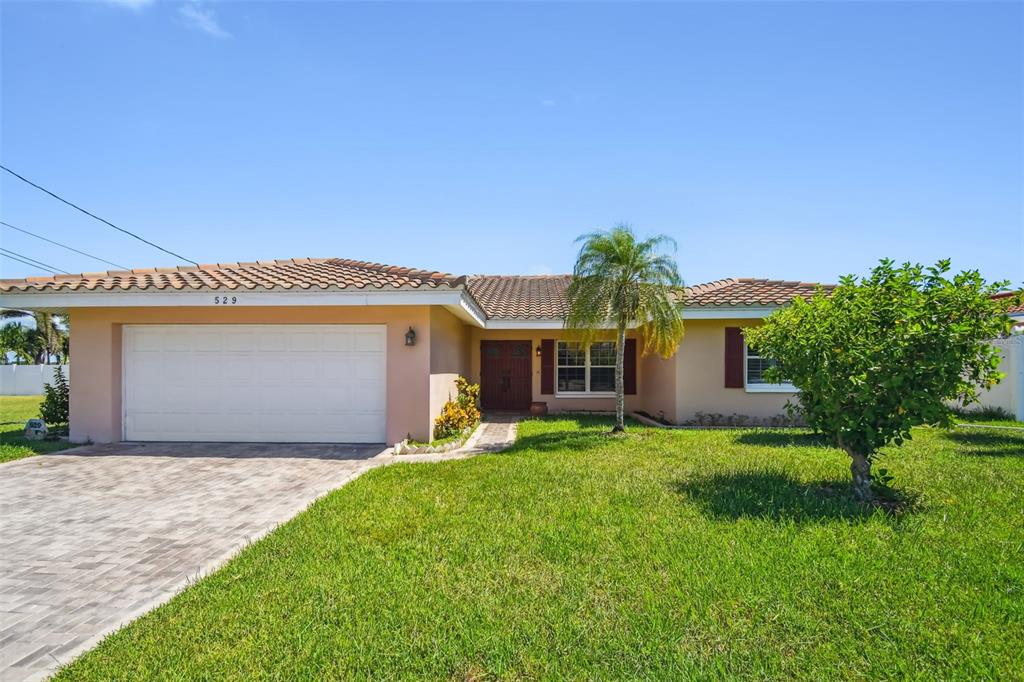 529 Johns Pass Avenue Madeira Beach, FL 33708 - Photo 9 of 100 a front view of a house with a yard and garage