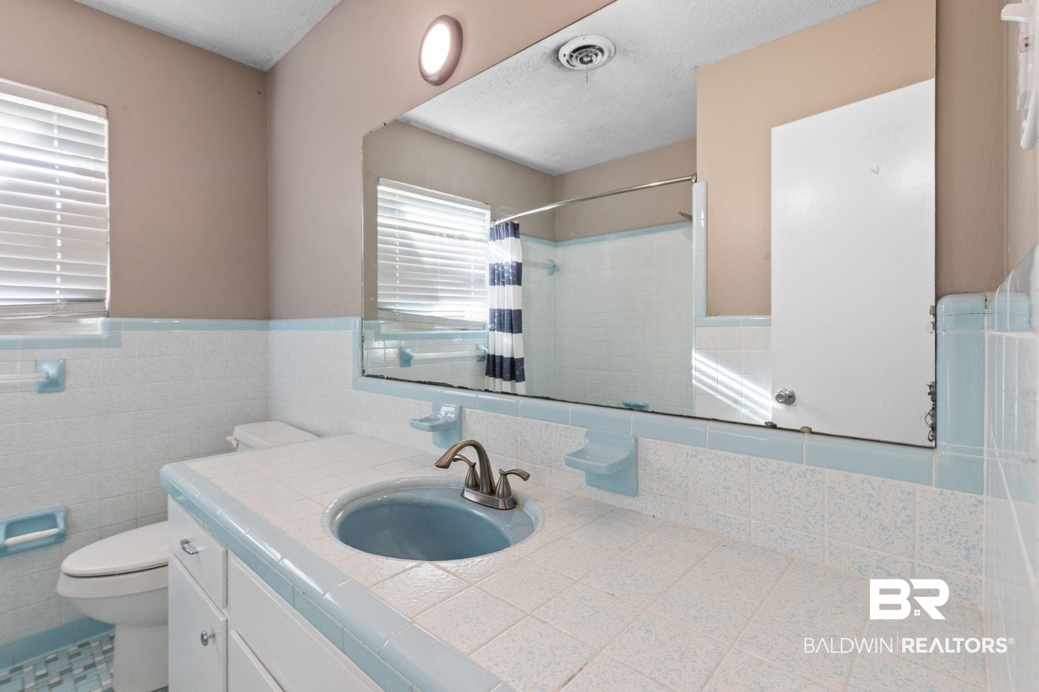 3864 Leroy Stevens Road Mobile, AL 36619 - Photo 25 of 33 Bathroom featuring vanity, curtained shower, tile walls, and wainscoting
