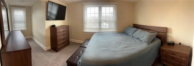 a bed sitting in a bedroom next to a window