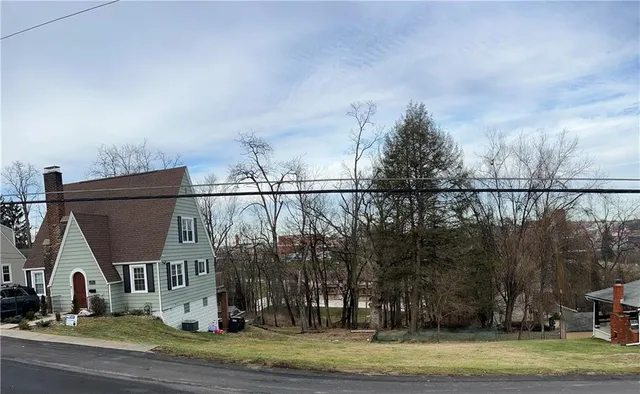 a view of a town with large trees and a small barn