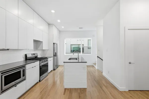 a kitchen with granite countertop white cabinets and white appliances