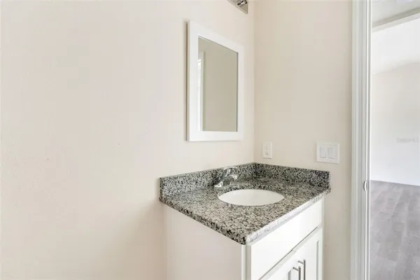 a bathroom with a granite countertop sink and a mirror