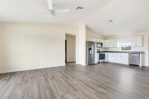 a view of a kitchen with wooden floor and a kitchen