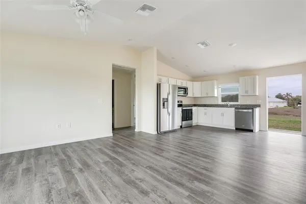 a view of a kitchen with a sink a refrigerator and a stove top oven