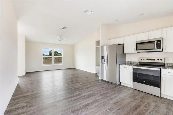 a view of kitchen with wooden floor and electronic appliances