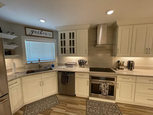 a kitchen with stainless steel appliances granite countertop a stove a sink and a microwave